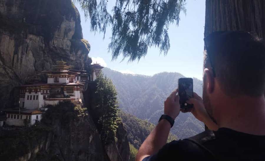 Gast van Himalayan Dream Team fotografeert het Tiger's Nest-klooster op een indrukwekkende rotswand in Paro, Bhutan.